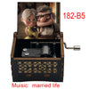 A wooden music box featuring two characters, a woman and a man, with a hand crank mechanism.
