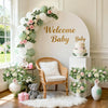 Exhibición floral blanca y verde con ramas de eucalipto, rosas y decoración para bebé para un tema de bienvenida de bebé.