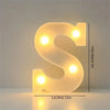 A glowing, translucent letter S made of LED lights, used for cozy room or party decor.