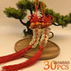 Traditional Chinese knot pendant featuring a wooden gourd and copper coins displayed on a wooden platter.