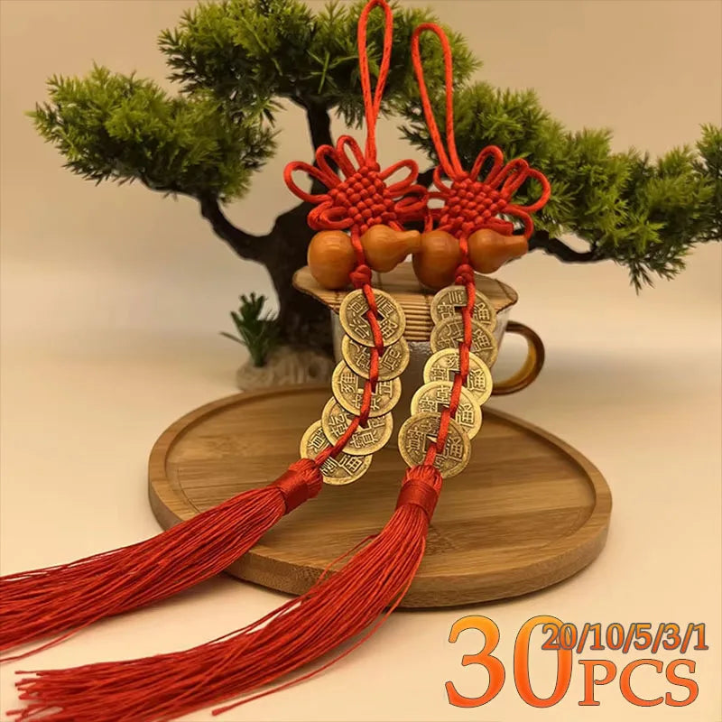 Traditional Chinese knot pendant featuring a wooden gourd and copper coins displayed on a wooden platter.