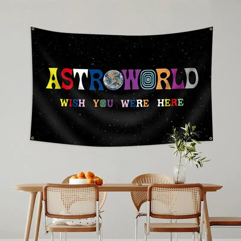 A black tapestry wall hanging featuring the text ASTROWORLD and the phrase WISH YOU WERE HERE with colorful lettering.