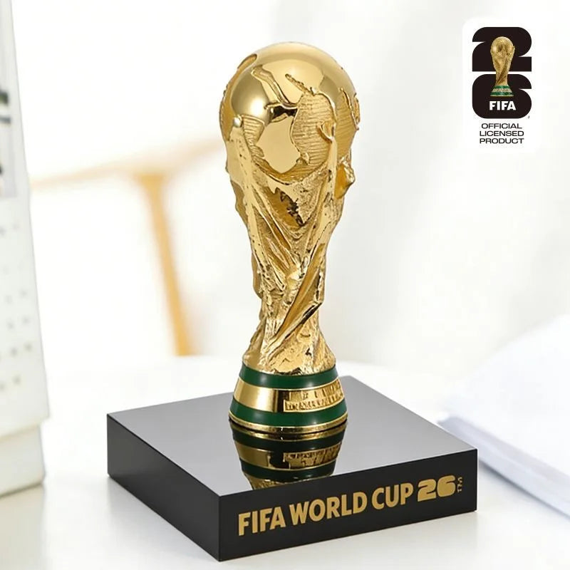 A gold FIFA World Cup 2026 trophy figurine displayed on a black square base.