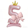 A foil balloon shaped like the number 5, pink, with a gold crown on top.