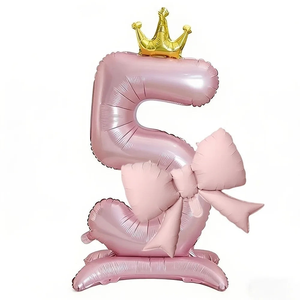 A foil balloon shaped like the number 5, pink, with a gold crown on top.
