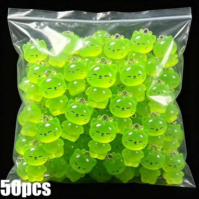A bag of 50 glow-in-the-dark resin charms shaped like cats and ducks in various shades of neon green.