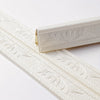 White self-adhesive foam wall trim strips with embossed leaf patterns.