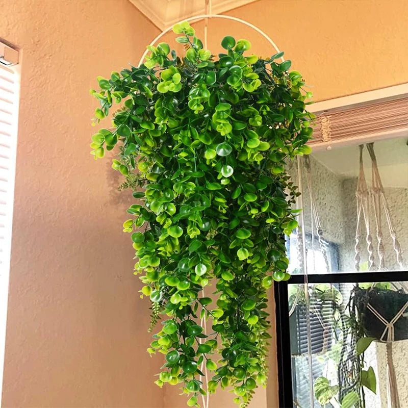 A hanging artificial eucalyptus plant with bright green leaves decoratively displayed on a wall.