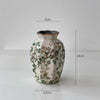 A white ceramic milk pitcher with a pastoral floral design and a cracked glaze, shown against a white background.