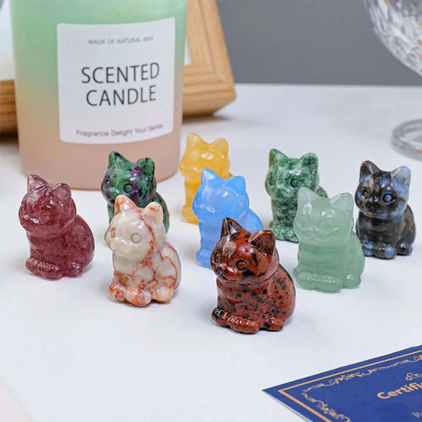 Collection d'ornements de chats en cristal sculptés à la main, de diverses couleurs (rose, jaune, vert, bleu).