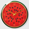 A round red clock face with black fruit designs and gold accents.