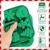 A hand holds a green silicone mold set featuring festive shapes for cookies and chocolate