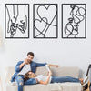 A couple relaxing on a couch in front of three framed black line art prints depicting holding hands, love, and kissing motifs