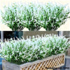 A dense arrangement of artificial white and green lavender stems in a wooden planter box.