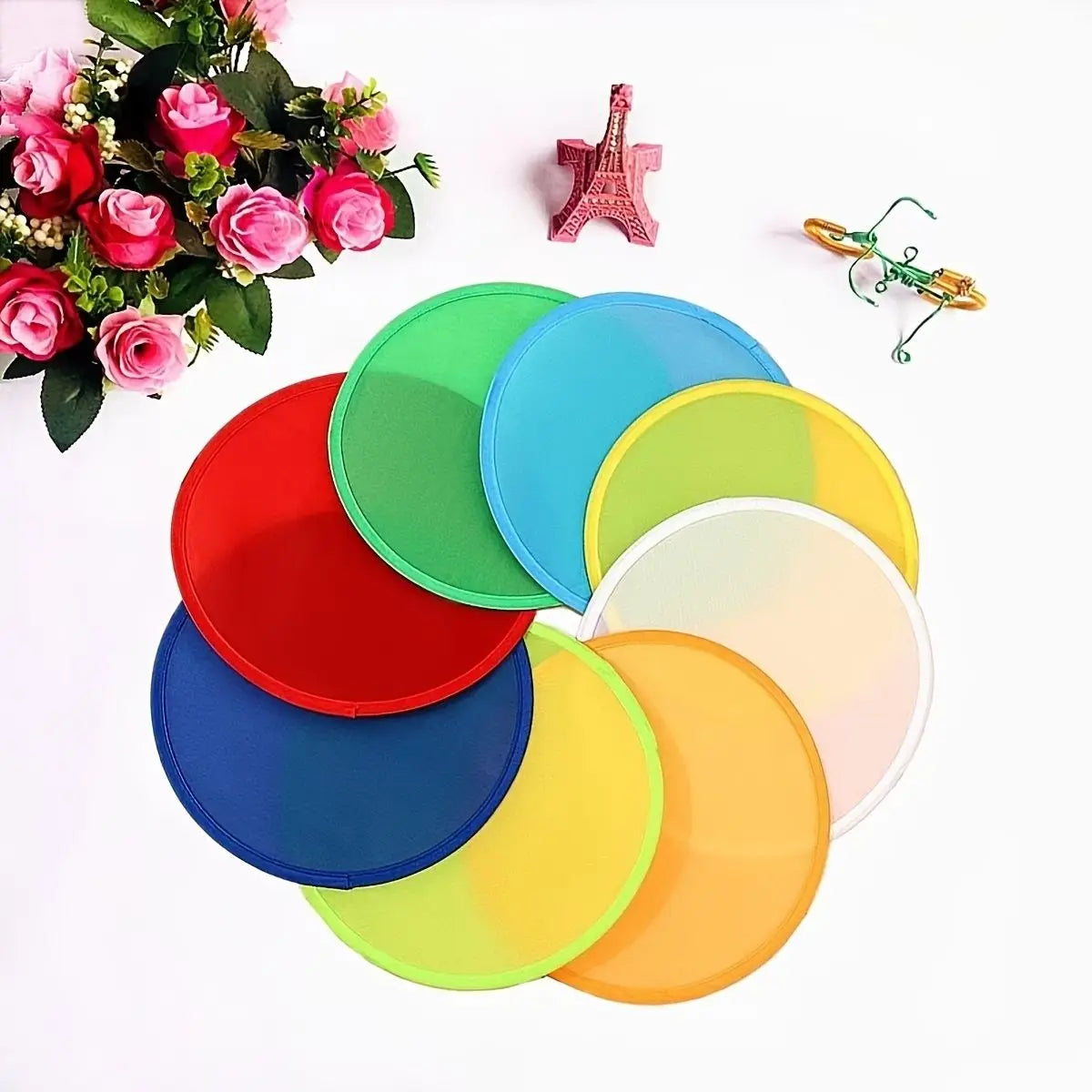 A collection of six colorful, round cooling fans in various shades of green, pink, red, blue, and yellow are displayed on a w