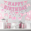 Glitter pink bow birthday banner strung across a white wall with pink balloons and gift boxes