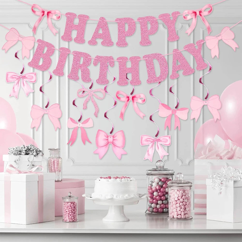 Glitter pink bow birthday banner strung across a white wall with pink balloons and gift boxes