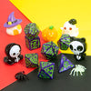 A set of seven polyhedral dice in various colors and shapes including a witch hat, pumpkin, and skull.