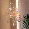 Crystal rainbow wind chime decor featuring sparkling pink and iridescent snowflakes hanging in a light beam.