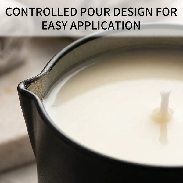 A dark tin candle holder filled with white massage oil, showing a controlled pour design for easy application.