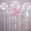 A collection of clear balloons with confetti and tassels in pink, blue, and yellow colors.