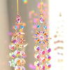 A pair of hanging crystal sun and moon charms featuring iridescent glass beads and gold accents.