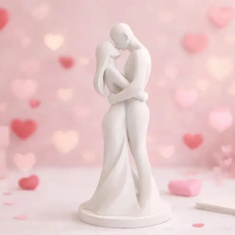 A white sculpture of a romantic couple hugging, set against a soft pink background with bokeh lights.
