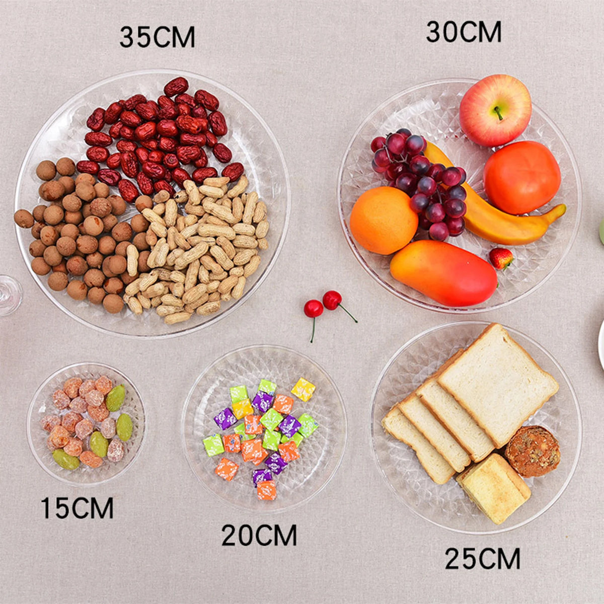 Clear acrylic serving plates display various dried fruits, nuts, and fresh fruit in different sizes.
