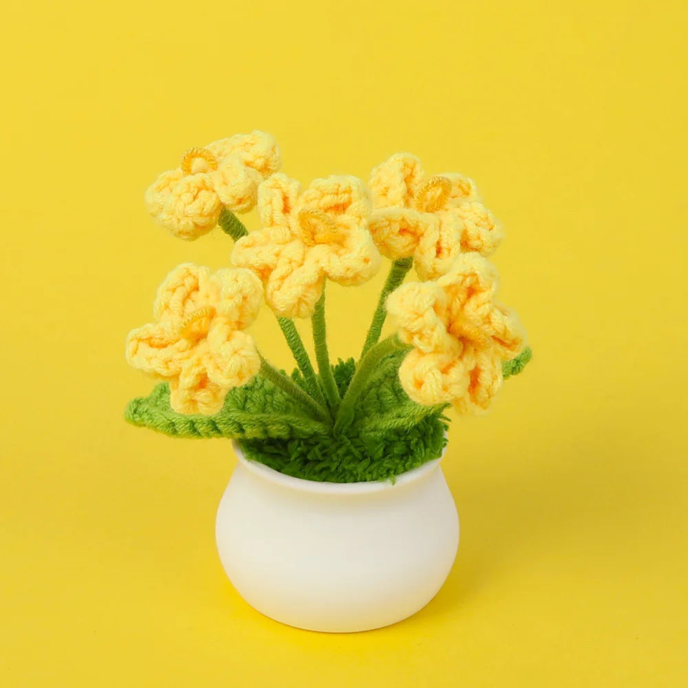 Hand woven crochet yellow flowers in a white pot on a yellow background