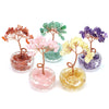 A collection of crystal healing gemstone bonsai trees in various colors including pink, green, purple, and yellow.