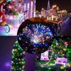 A festive display of fairy string lights illuminating a garden scene, including a Christmas tree and decorative elements.