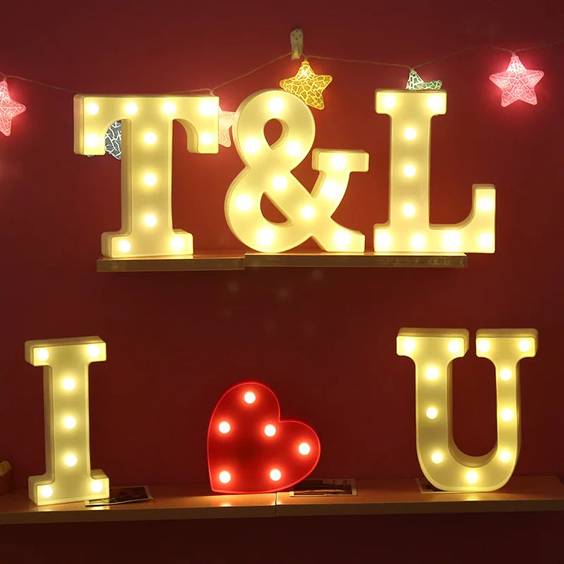 Warm white LED alphabet letter lights spelling T&L and IU mounted on a red wall.