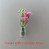 A small glass vase holding pink flowers with green stems
