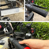 A hand is installing a silicone grip cover onto a motorcycle handlebar.