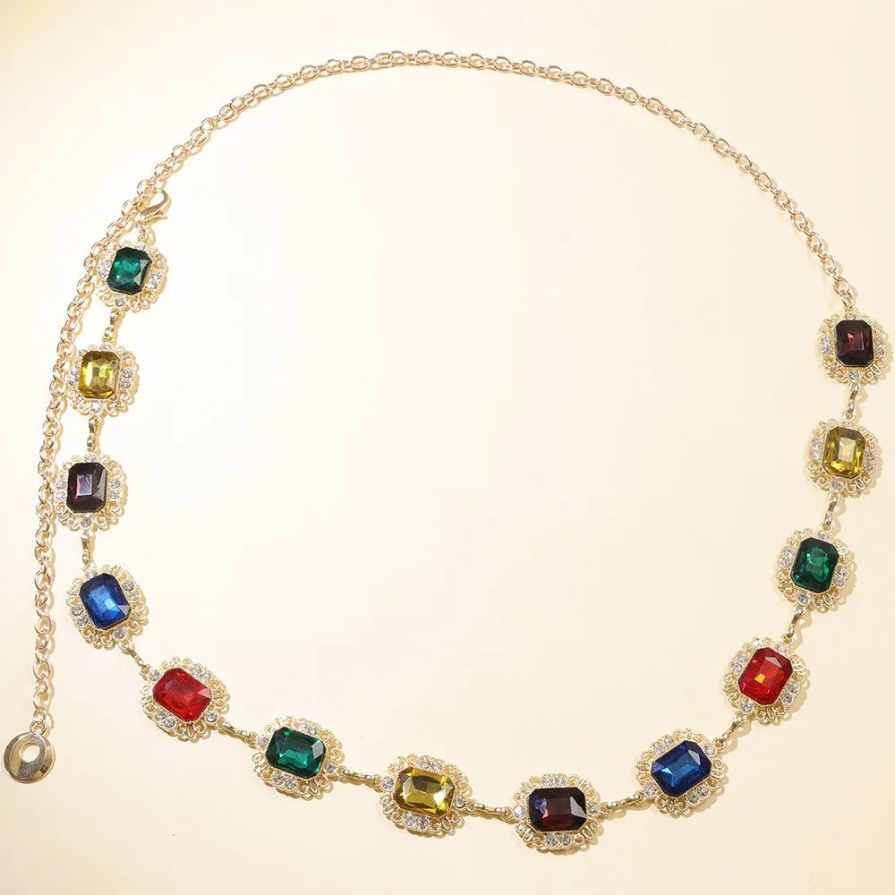 A gold chain necklace featuring colorful crystal gemstones in various shades of green, blue, red, and yellow.