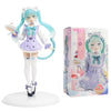 A PVC collectible figurine of Hatsune Miku in a white and purple outfit with teal hair, displayed on a round base.