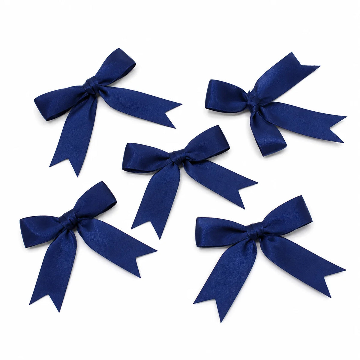 A collection of dark blue satin ribbon bows tied in various decorative styles.