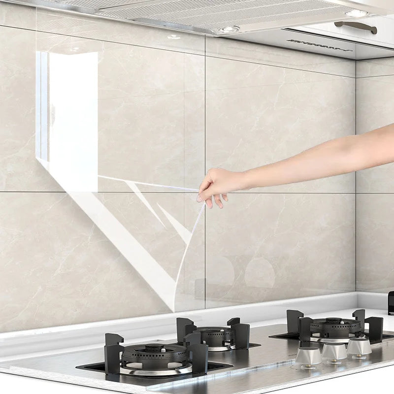 A hand is touching a clear oil-proof self-adhesive film applied to a kitchen wall surface.