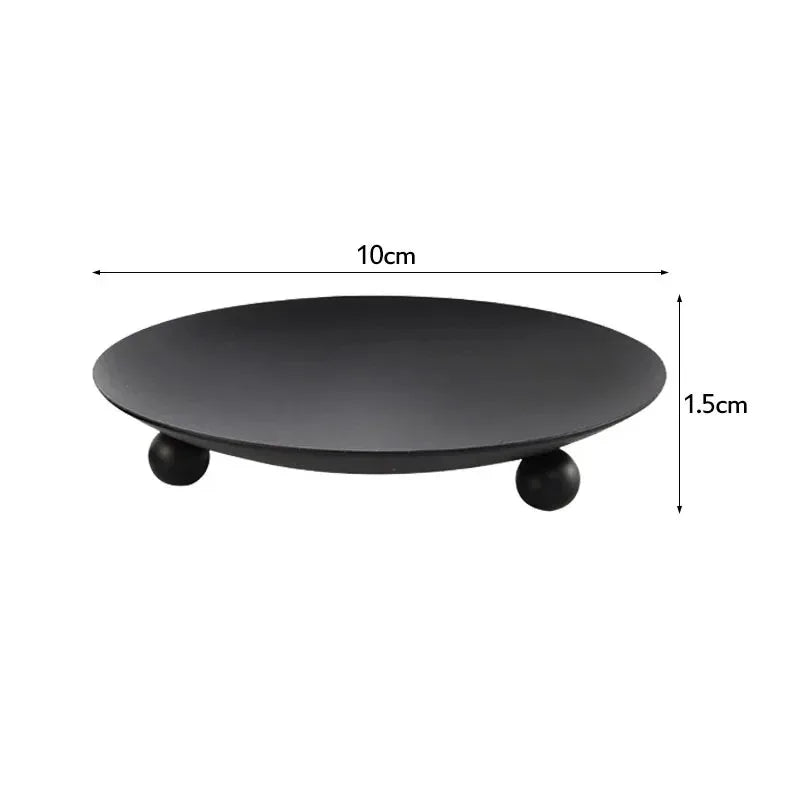 A black iron candle holder tray with gold accents, shown from above.