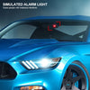 A close-up of a blue car's headlight with a red simulated alarm light visible.