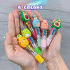 A hand holds a set of five cute cartoon mini ballpoint pens in various colors, including green, blue, pink, and yellow.