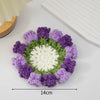 Hand-crocheted rose flower coasters featuring purple and green yarn petals.