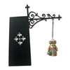 A black decorative sign with an ornate wrought iron hook holding a small, antique-style lantern charm.