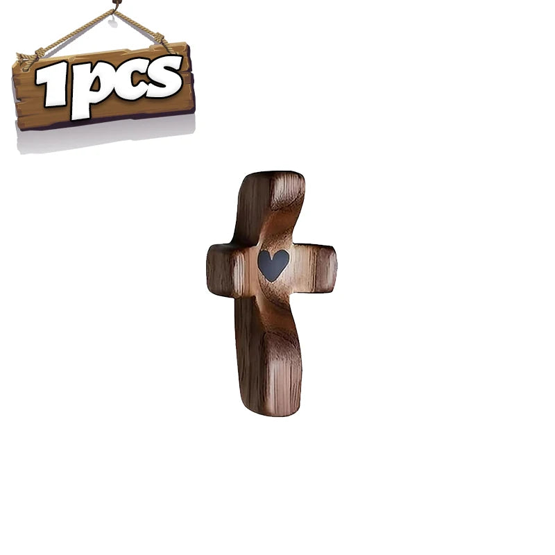 A wooden pocket cross with a heart carved into the center for prayer and reflection.