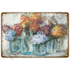 A vintage metal tin sign featuring a painting of colorful flowers in glass vases.