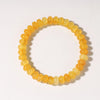 A bracelet made of round, translucent yellow-orange citrine crystals.