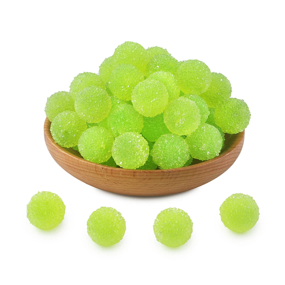 A pile of bright lime green textured resin beads for jewelry making in a wooden bowl.