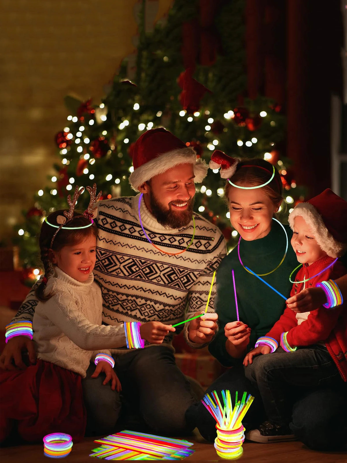 A family of three celebrating with colorful glow sticks and bracelets in a festive holiday setting.