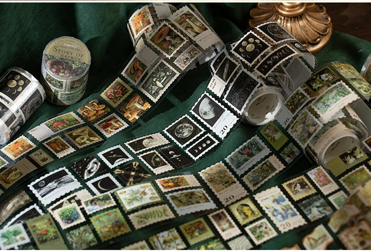 A collection of decorative washi tape squares in various natural and vintage patterns arranged on a green fabric.