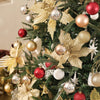 A close-up of a Christmas tree decorated with various gold, silver, and red baubles and star ornaments.